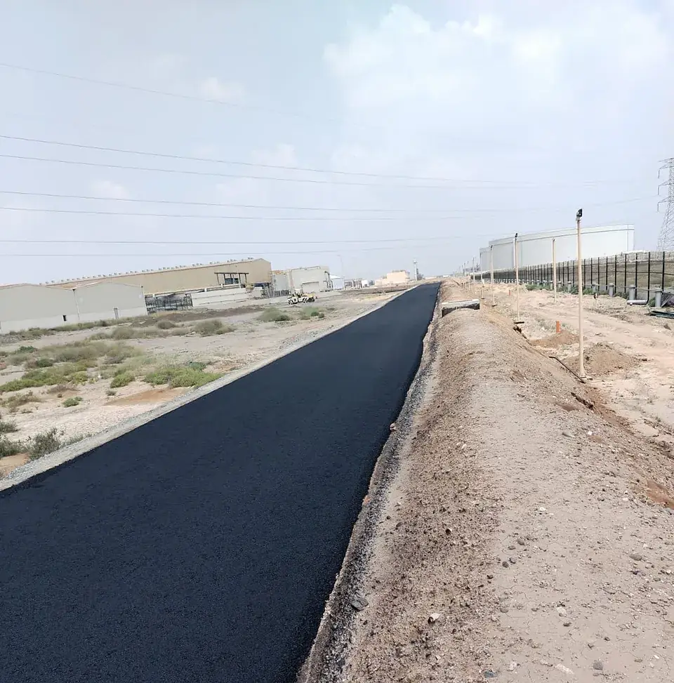 Finished asphalt road beside the plant fence