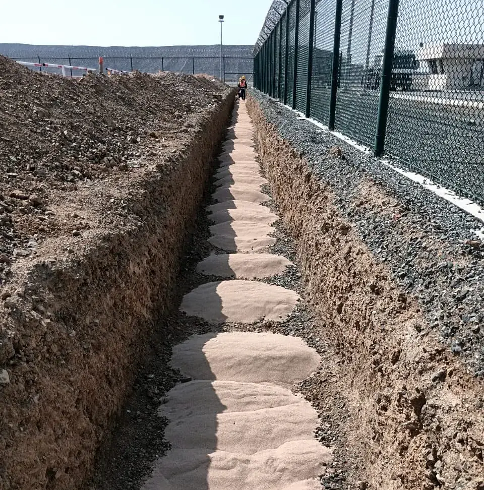 Sand-bedded trench along the fence line